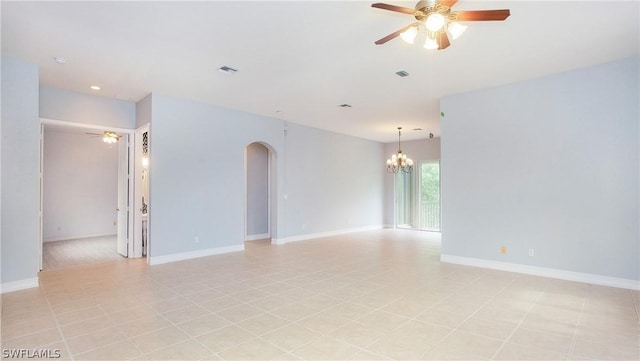 spare room featuring baseboards, visible vents, arched walkways, and ceiling fan with notable chandelier