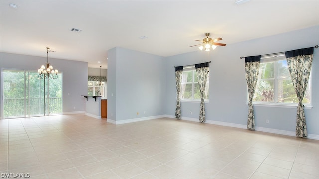 unfurnished room featuring ceiling fan with notable chandelier and light tile patterned floors