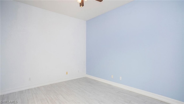 empty room with a ceiling fan, light wood-style flooring, and baseboards