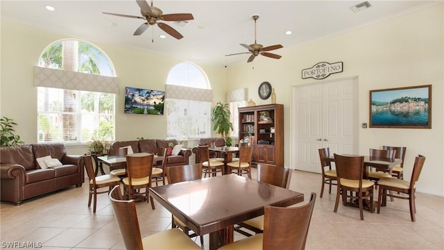 tiled dining area featuring ceiling fan and crown molding