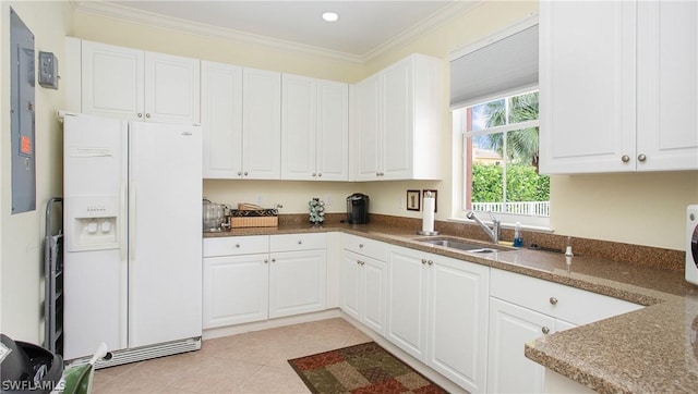 kitchen with white refrigerator with ice dispenser, white cabinets, crown molding, sink, and light tile patterned flooring