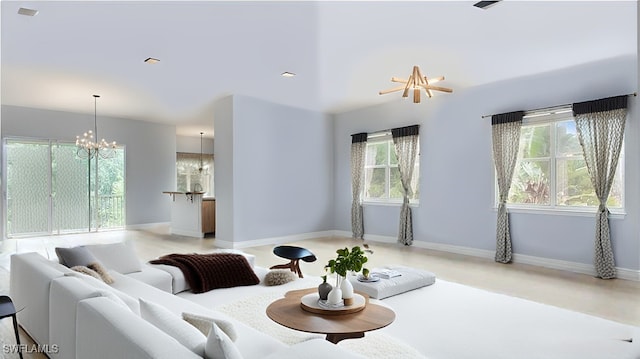 sunken living room featuring baseboards and a notable chandelier