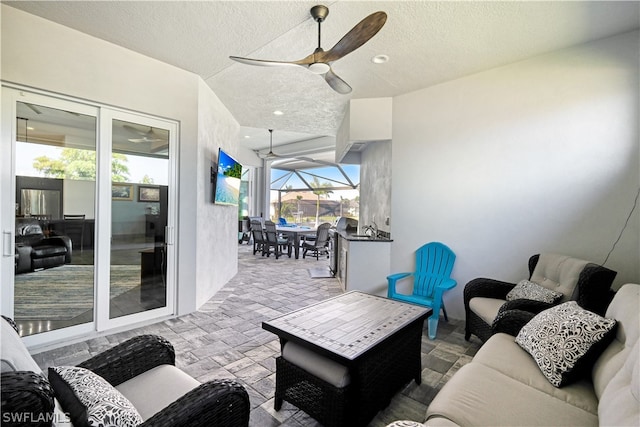 living room with a textured ceiling and ceiling fan