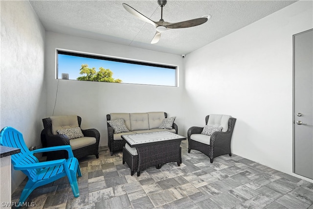 sitting room featuring ceiling fan and a textured ceiling