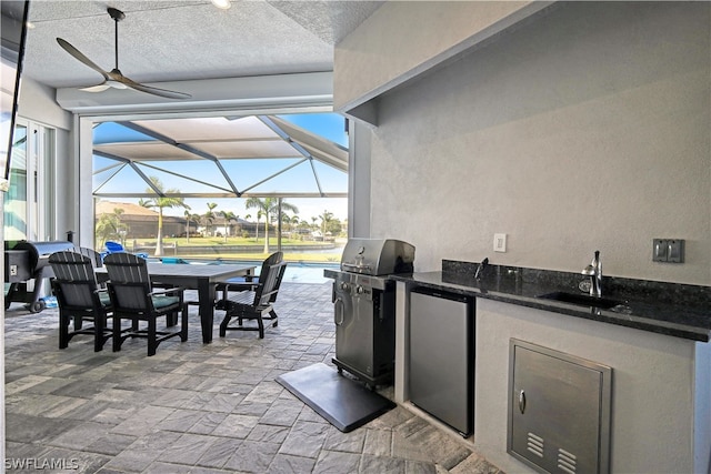 view of patio / terrace with sink, glass enclosure, exterior kitchen, and area for grilling