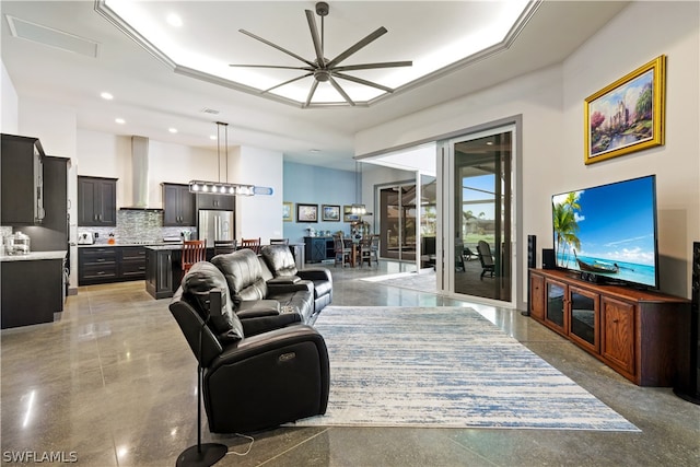 living room featuring a tray ceiling and ceiling fan