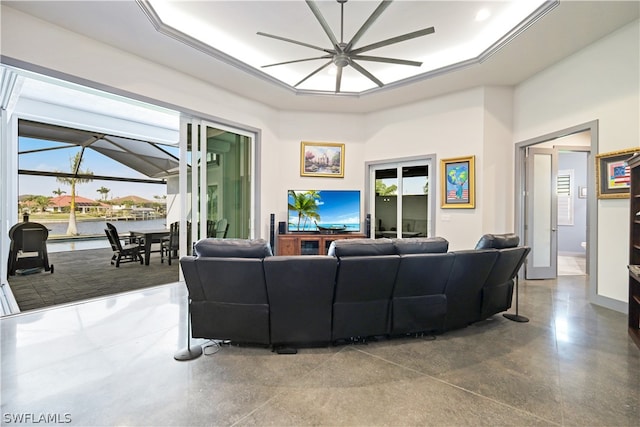 living room featuring ceiling fan and a tray ceiling