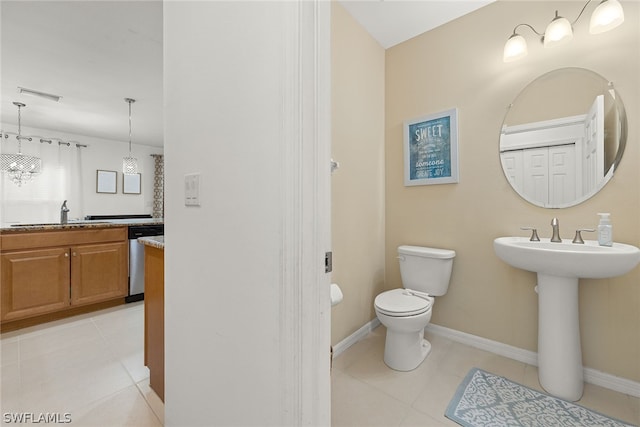 bathroom featuring tile patterned flooring, sink, an inviting chandelier, and toilet