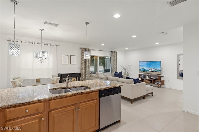 kitchen with stainless steel dishwasher, light stone countertops, sink, and decorative light fixtures