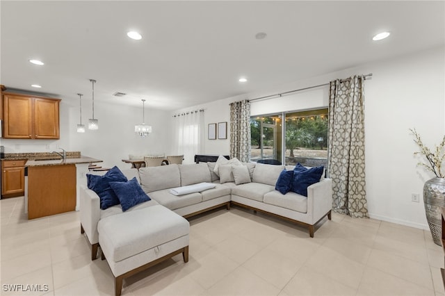 living room featuring a chandelier and sink