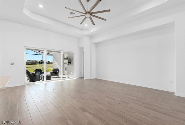 unfurnished room with ceiling fan and a tray ceiling