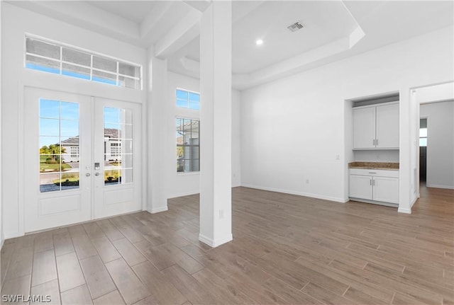 foyer entrance with french doors and a tray ceiling