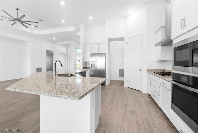 kitchen with stainless steel appliances, a large island with sink, white cabinetry, and sink