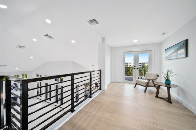 hall with vaulted ceiling, french doors, and light hardwood / wood-style flooring