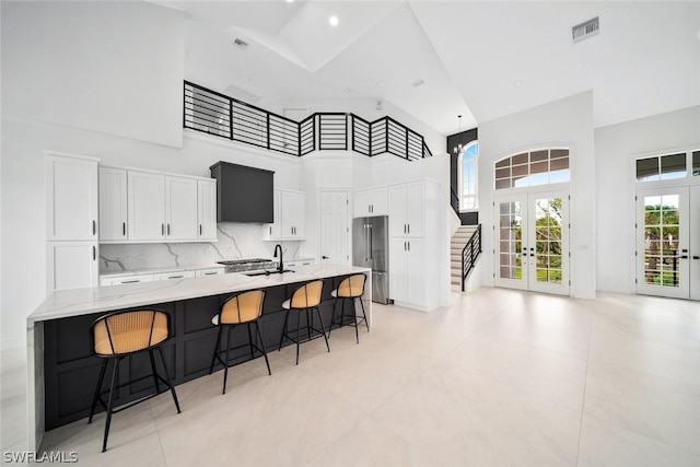 kitchen featuring french doors, sink, white cabinetry, a high ceiling, and high end refrigerator