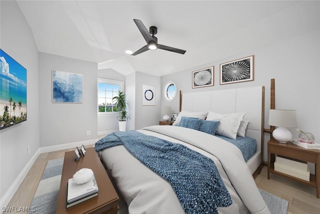 bedroom with ceiling fan, light hardwood / wood-style flooring, and vaulted ceiling