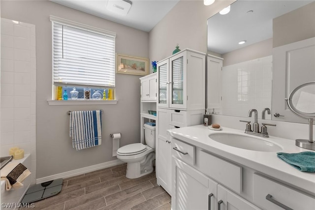 bathroom featuring a washtub, vanity, and toilet