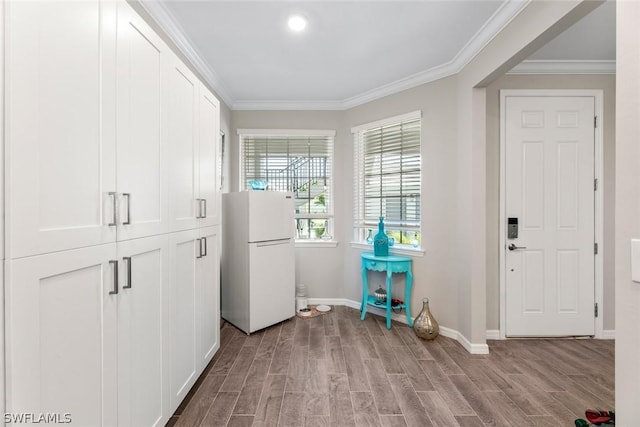 entryway with light hardwood / wood-style flooring and ornamental molding