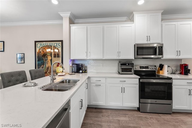 kitchen with decorative backsplash, white cabinetry, sink, and stainless steel appliances