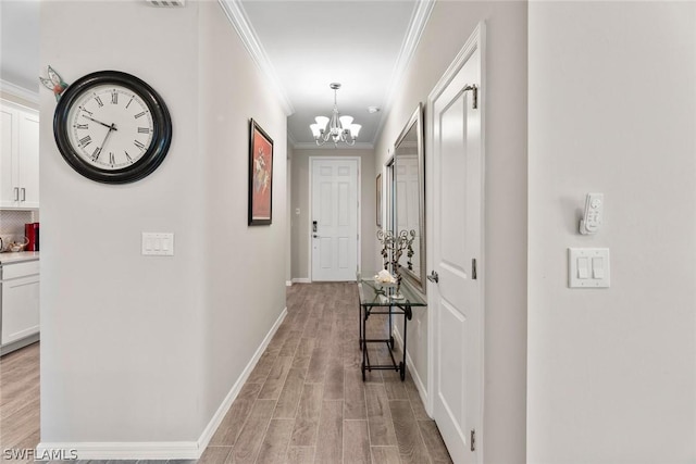 hall with ornamental molding and a notable chandelier