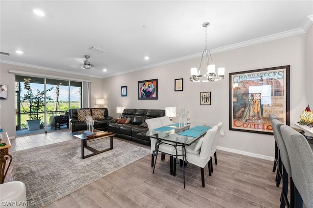 dining space with ceiling fan with notable chandelier and ornamental molding