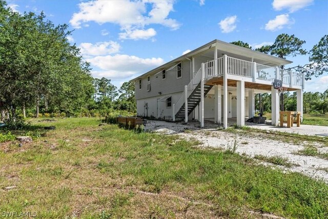 back of property with a deck and a patio