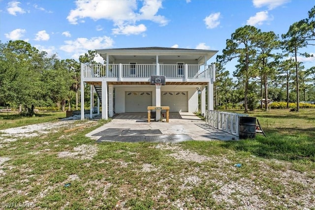 back of house with a garage, a lawn, and covered porch