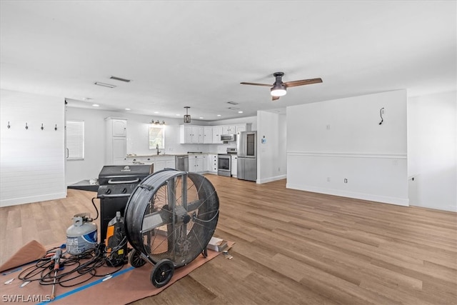 interior space featuring ceiling fan, light wood-type flooring, and sink