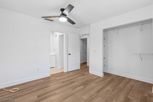 unfurnished bedroom featuring ceiling fan, ensuite bathroom, a closet, and light wood-type flooring