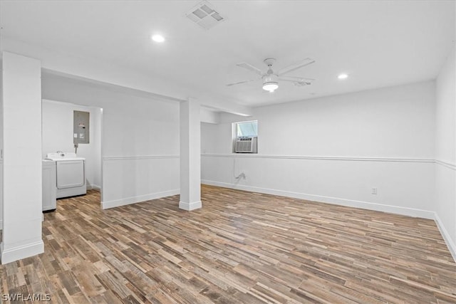 basement featuring washer and dryer, cooling unit, ceiling fan, and light hardwood / wood-style flooring