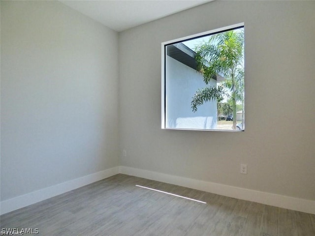 unfurnished room with a wealth of natural light and hardwood / wood-style floors