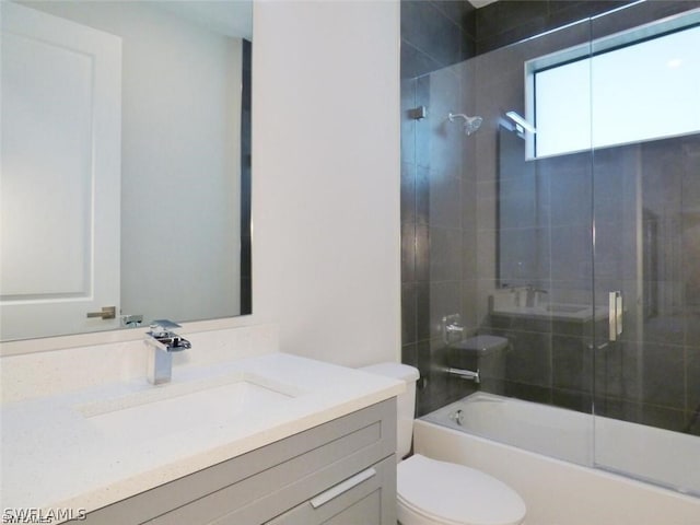 full bathroom featuring toilet, bath / shower combo with glass door, and vanity