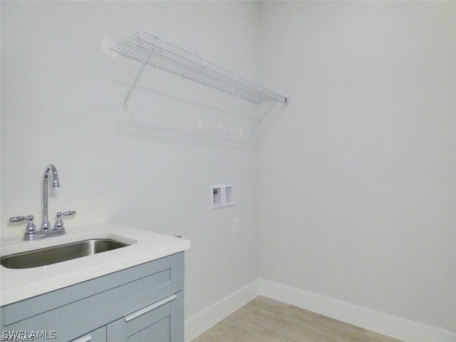 clothes washing area featuring sink, hookup for a washing machine, and light wood-type flooring