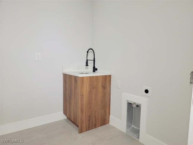 laundry area with baseboards, a sink, and hookup for an electric dryer