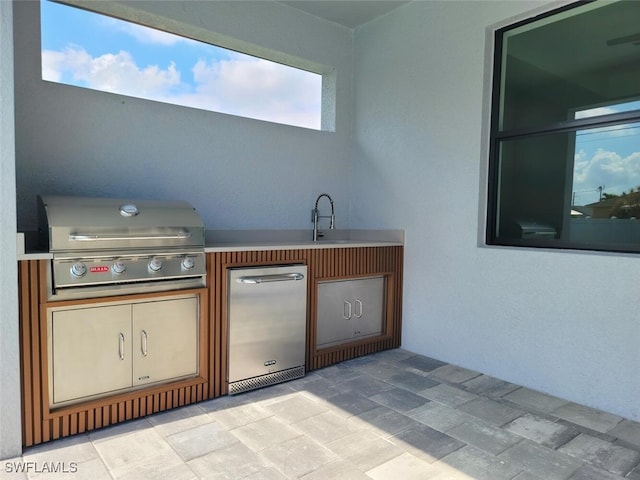 view of patio featuring exterior kitchen, a grill, and a sink