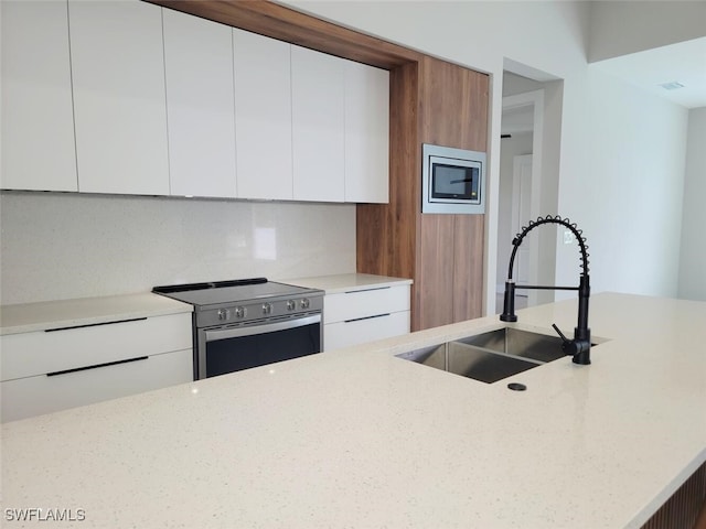 kitchen with appliances with stainless steel finishes, modern cabinets, and white cabinetry