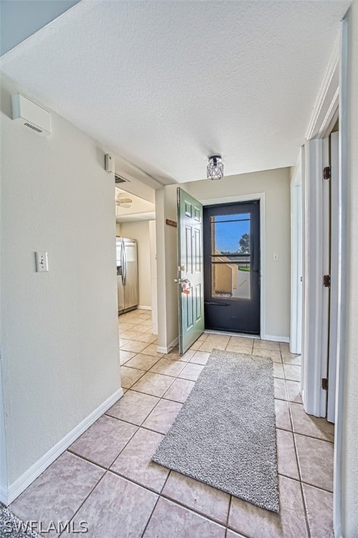 tiled foyer featuring a textured ceiling