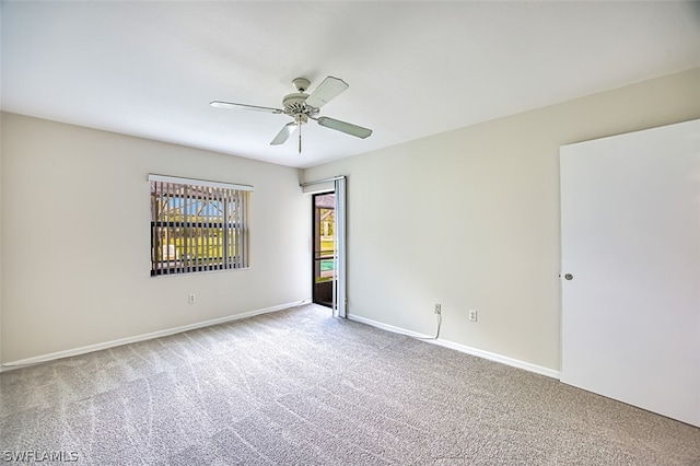 carpeted spare room featuring ceiling fan