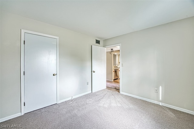 unfurnished bedroom featuring a closet and light colored carpet