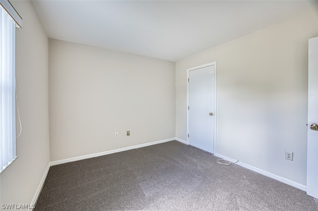 empty room featuring dark carpet and a healthy amount of sunlight