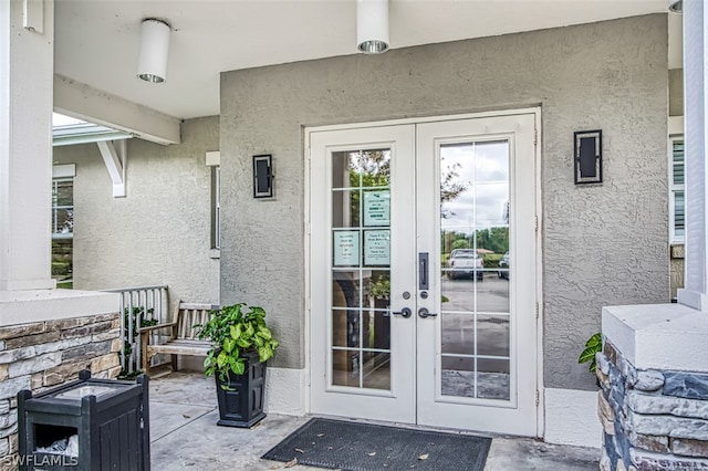 property entrance featuring covered porch and french doors