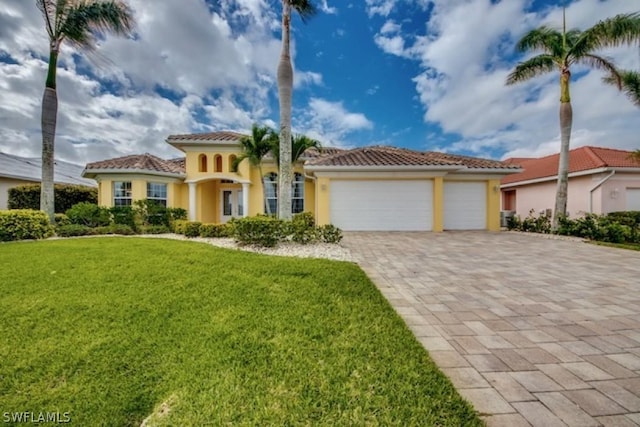 mediterranean / spanish house featuring a front yard and a garage