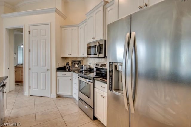 kitchen with white cabinets, stainless steel appliances, tasteful backsplash, and light tile patterned flooring