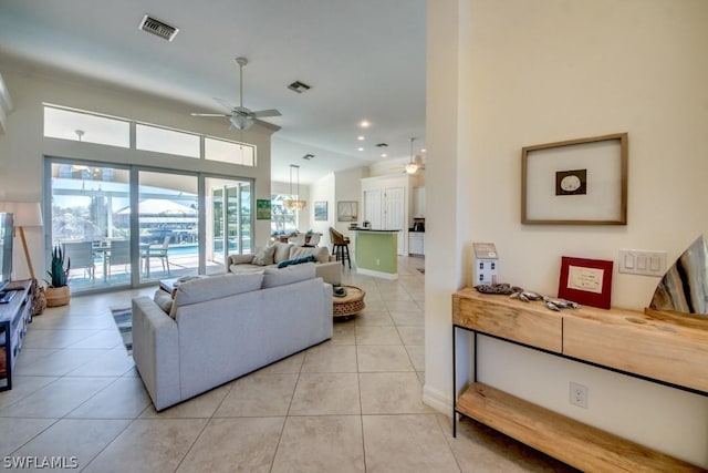 living room with ceiling fan, light tile patterned floors, and lofted ceiling