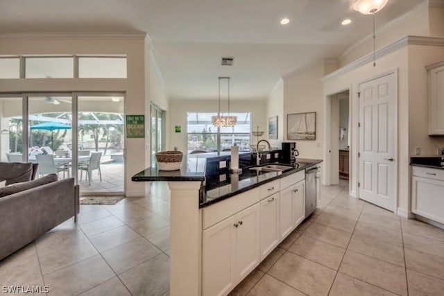 kitchen with pendant lighting, dishwasher, white cabinets, sink, and an island with sink