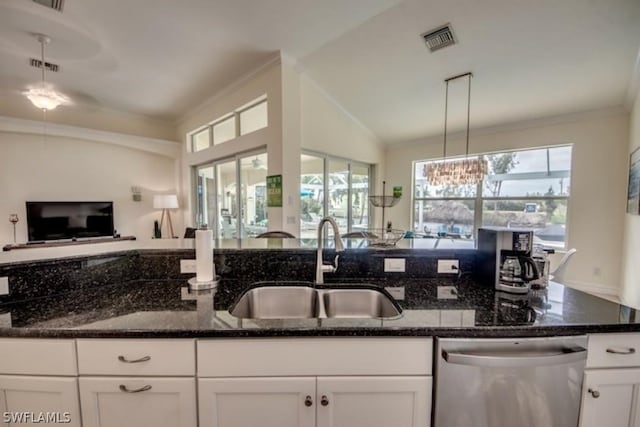 kitchen with white cabinetry, stainless steel dishwasher, dark stone counters, and sink