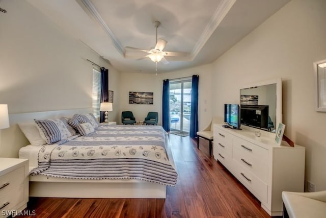 bedroom with ornamental molding, access to outside, a tray ceiling, ceiling fan, and dark hardwood / wood-style floors