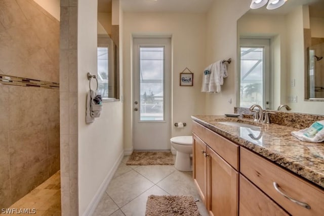 bathroom with tile patterned flooring, vanity, toilet, and walk in shower