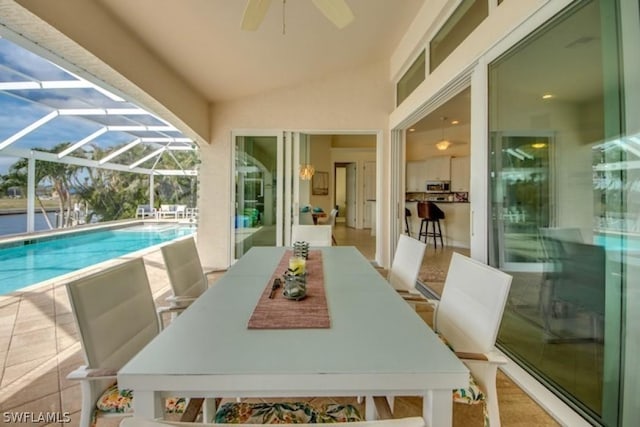 exterior space with vaulted ceiling, ceiling fan, and a swimming pool