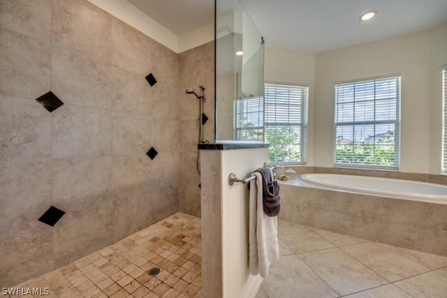 bathroom with tile patterned flooring and shower with separate bathtub